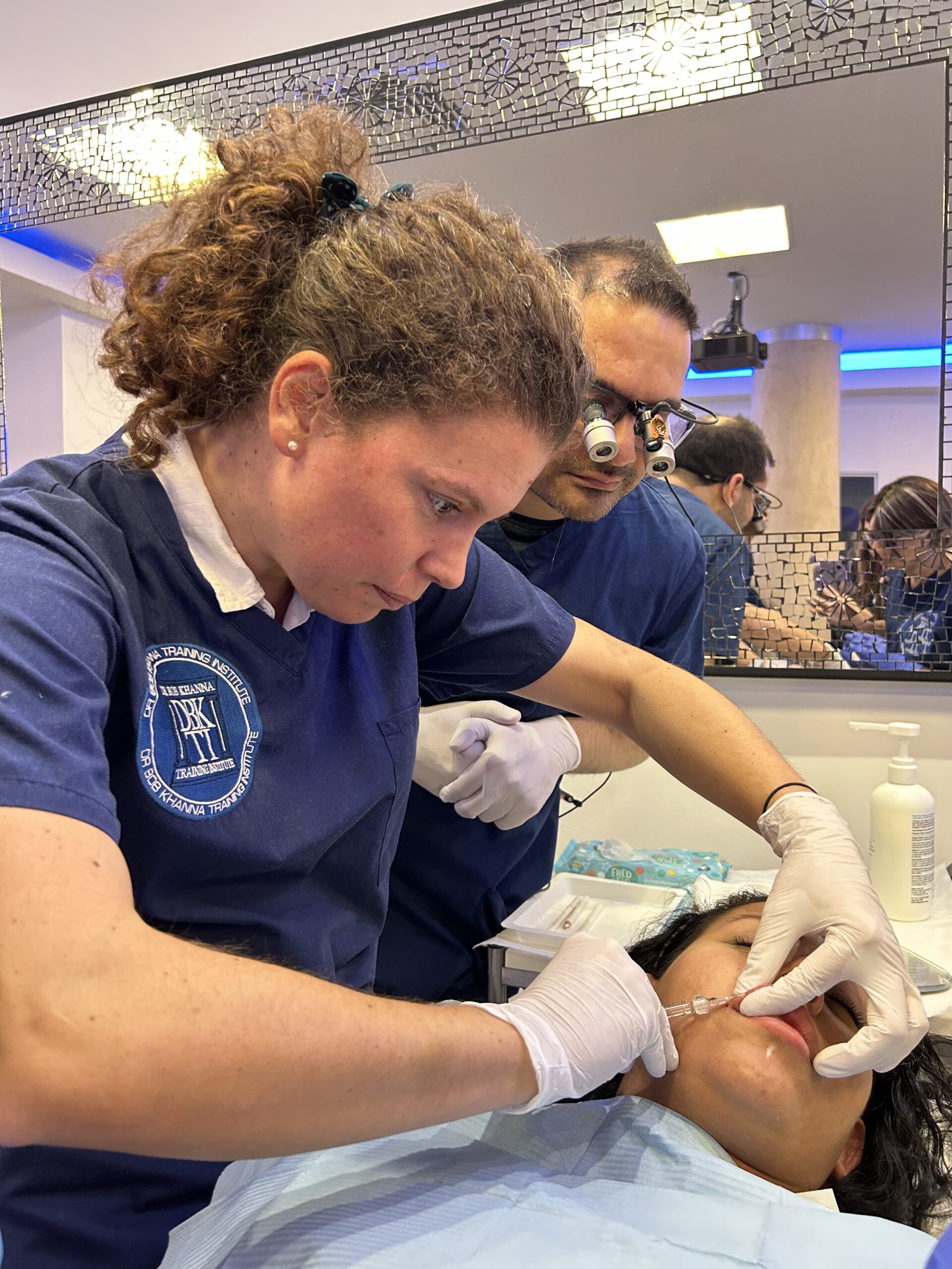 A doctor on a training course performing dermal filler treatment